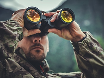 Man hunting using binoculars