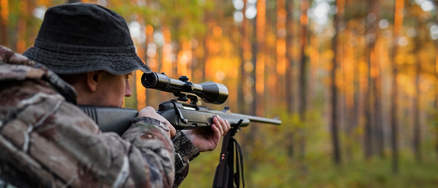 hunter using scoped rifle