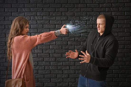 Woman spraying an attacker with pepper spray